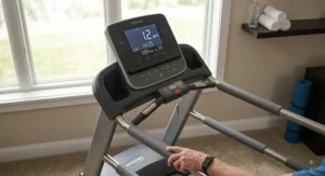 Easy-to-read console display on a treadmill with extra side rails for elderly home workouts.